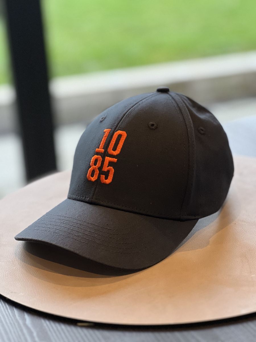 Marinblå keps med orange broderat 1085-tryck och Lomma Beachwear-lapp